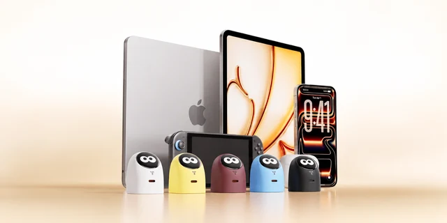 Os cinco carregadores TORRAS, nas cores branco, amarelo, vinho, azul e preto, diante de computador portátil, tablet, telemóvel e consola portátil